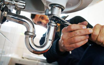 Close-up of plumber repairing sink. Male worker using tool while fixing appliance in bathroom. He is working on metallic equipment at home.